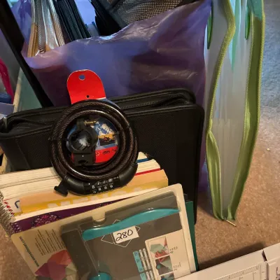 Assortment of office, crafting, and travel supplies, including a We R Memory Keepers Envelope Punch Board, paper trimmer, notebooks, bike...