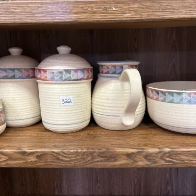 Five-piece Pfaltzgraff Pueblo stoneware pottery set, including canisters, a pitcher, a bowl, and a mug, featuring a Southwestern...