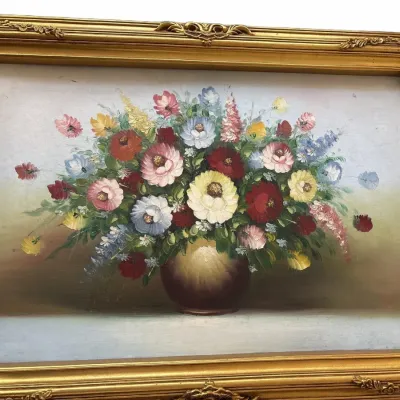 Vintage impasto oil painting of a vibrant floral bouquet in a rounded vase, housed in an ornate gilded frame.