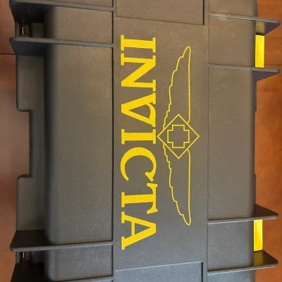 Black plastic Invicta brand hard-shell watch collector case with yellow logo and side latches.