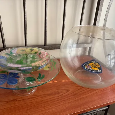 Hand-painted floral glass cake stand with matching plates, displayed alongside a large clear glass fishbowl or punch bowl.