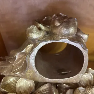 Vintage gold-toned napkin ring adorned with a sculpted rose and leaf design.