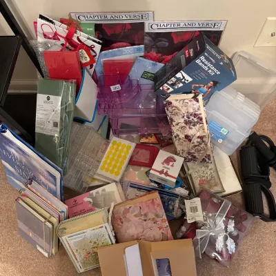 Large assortment of stationery, craft supplies, notebooks, gift wrap accessories, and a boxed resistance bands fitness kit.