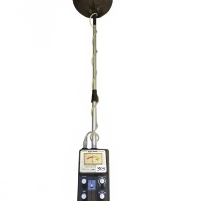 Vintage Radio Shack VLF metal detector featuring an analog display meter and multiple adjustment dials on the control box.