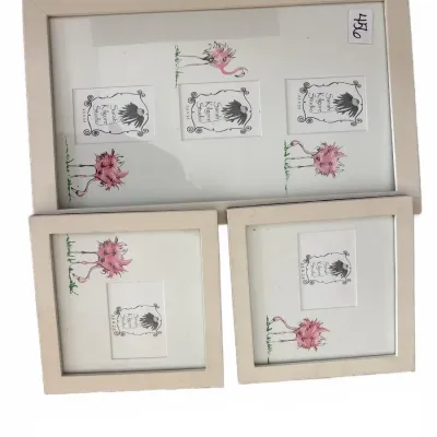 Set of three off-white picture frames with flamingo illustrations and photo mats by Sarah Kilgore Studio.