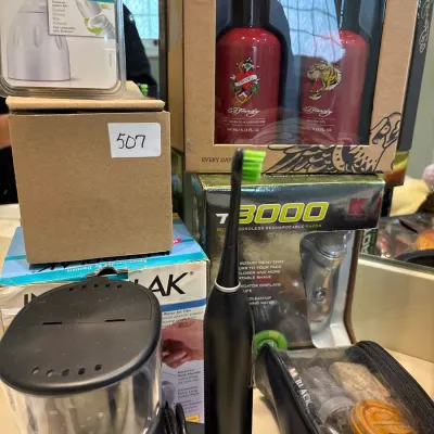 Collection of personal care products and grooming items, including an electric toothbrush, an Ed Hardy gift set, and a shoe shine kit.