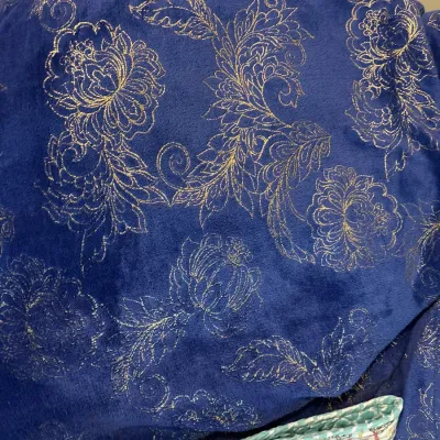 Plush royal blue blanket featuring a metallic gold foil floral and paisley pattern.
