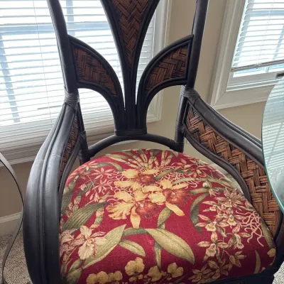 Dark brown rattan dining armchair with woven accent panels and a red floral upholstered seat.