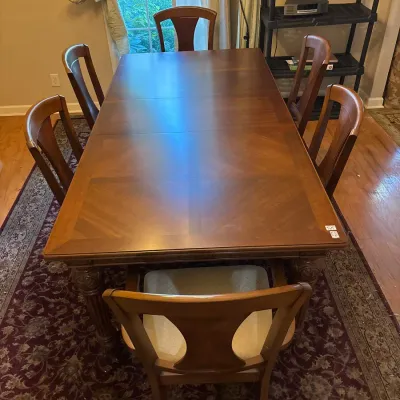 Traditional wooden dining table set with parquetry tabletop and six matching splat-back chairs with cushioned seats.