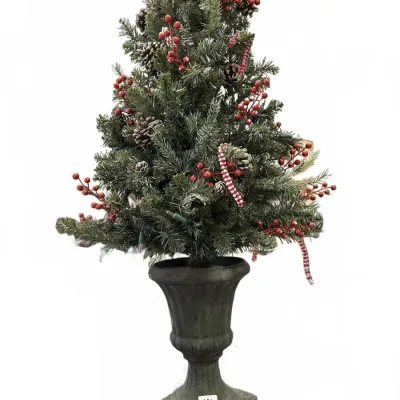 Small frosted tabletop Christmas tree set in a dark urn planter, decorated with red berries, pinecones, and candy cane ornaments.