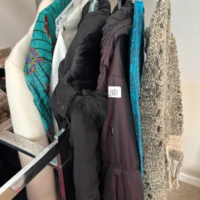 Clothing rack featuring a assortment of women's outerwear, including winter coats, jackets, and patterned garments.
