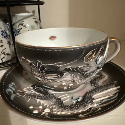 Vintage Japanese dragonware porcelain teacup and saucer set featuring raised moriage dragon motifs and gold rim accents.