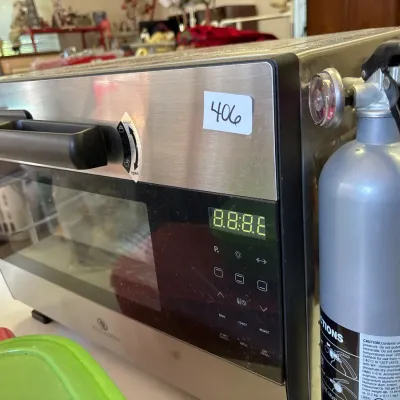 Modern stainless steel Paula Deen digital countertop toaster oven alongside a compact silver fire extinguisher.