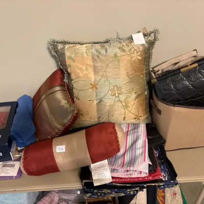 Collection of home textiles and accessories, including decorative throw pillows, a cylindrical bolster pillow, linens, Sperry Top-Sider...