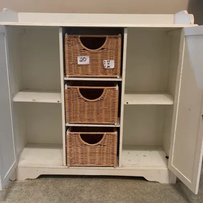 White painted wooden storage cabinet with two side doors and three center wicker basket drawers.