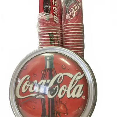 Vintage Coca-Cola wall clock with a silver frame alongside two unopened sleeves of vintage Coca-Cola paper cups.