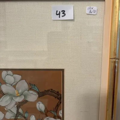 Framed floral art print featuring white blossoms on a brown background, housed in a gilt faux-bamboo frame with a linen mat, measuring 19...