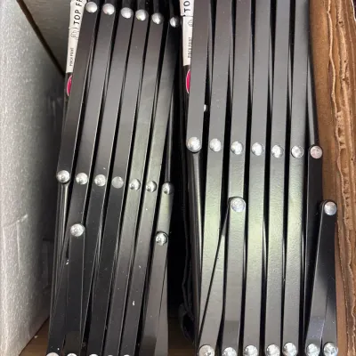 Set of black metal folding or scissor-style furniture frames packed tightly in a cardboard shipping box.