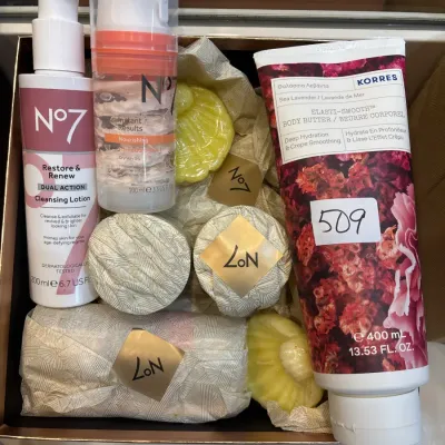 Collection of bath and skincare items including No7 cleansing lotion and hydration mask, Korres body butter, and wrapped soaps in a...