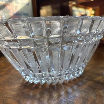 Vintage heavy cut-crystal serving bowl featuring intricate geometric panel designs and a saw-tooth rim.