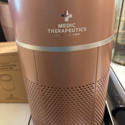 Medic Therapeutics Special Edition air purifier in rose gold, featuring a cylindrical design with lower ventilation grilles and a silver...