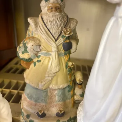 Vintage resin or ceramic Father Christmas figurine, detailed with pastel robes, a staff, floral accents, and a goose by his side.