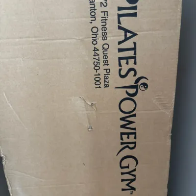 Pilates Power Gym fitness equipment inside its original cardboard shipping box.