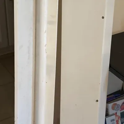 Pair of vintage white painted wooden corner shelf units showing light surface wear and scuffs.
