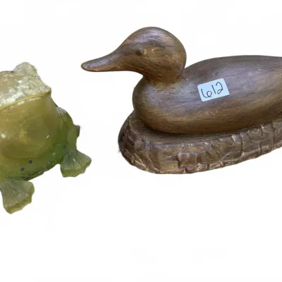 Pair of animal figurines featuring a green frosted glass frog and a carved wooden duck resting on a base.