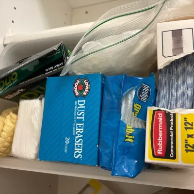 Assorted household cleaning supplies, including Lowes Foods Dust Erasers, Pledge Grab-it cloths, Rubbermaid disposable pads, and Shark...