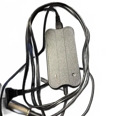 Black power supply adapter block with attached cords, featuring a multi-pin connector and standard wall plug.