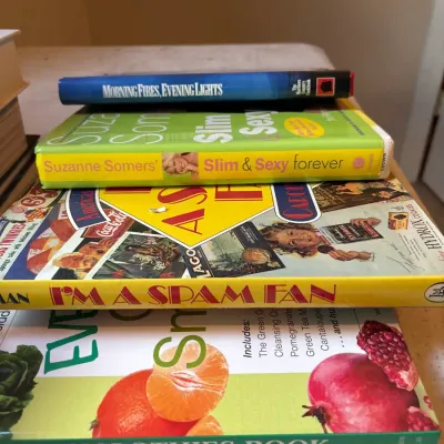 Small stack of vintage and modern hardcover books, including cookbooks and lifestyle titles such as "I'm a SPAM Fan" and...