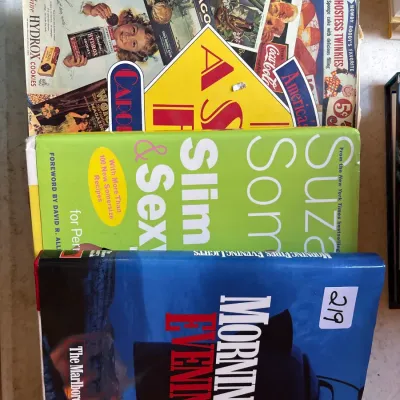 Stack of hardbound books, including 'The Marlboro Country Cookbook' and Susanne Somers diet books, showing minor shelf wear.