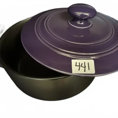Le Creuset style purple enameled lid resting on a black round Dutch oven or casserole pot.