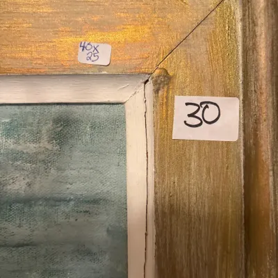 Close-up of a framed painting showing corner separation and wear on the gilded wood frame.