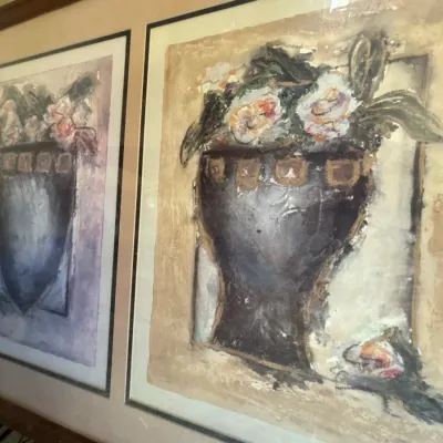Pair of impressionistic floral still-life prints featuring vases with flowers, mounted in a shared wooden frame behind glass.