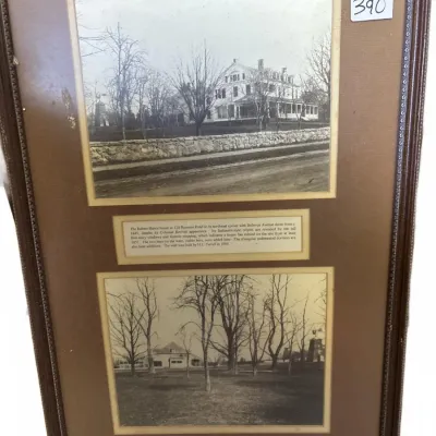 Framed historical display featuring two black and white photographs of a house and estate with descriptive text plaques, housed in a...