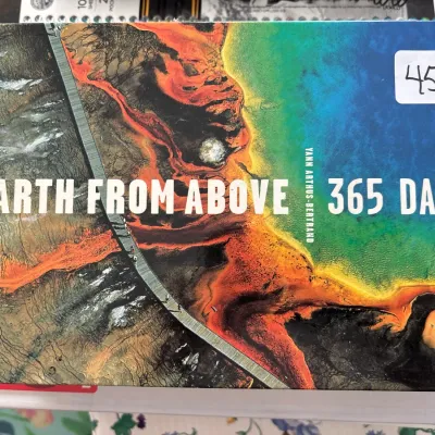 Hardcover coffee table book titled "Earth From Above: 365 Days" by Yann Arthus-Bertrand, featuring aerial photography.