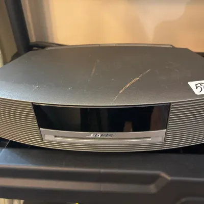 Bose Wave Music System in graphite gray with built-in CD player and front display, showing light surface scratches on the top casing.