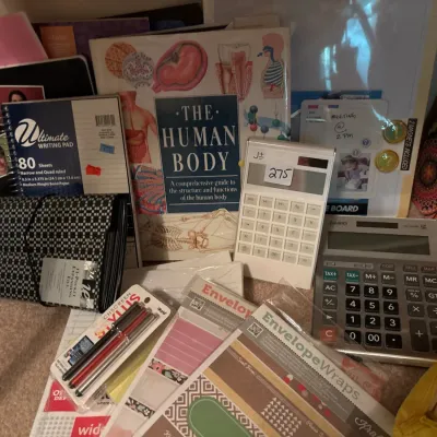 Collection of office and school supplies, including electronic calculators, notebooks, envelopes, stylus pens, and an anatomical...