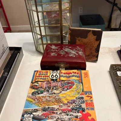 Selection of tabletop decor items, including a brass and glass display case, mother-of-pearl inlaid lacquered jewelry box, leather leaf...