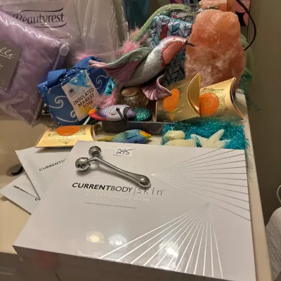 Assortment of beauty, home, and wellness goods, including a boxed CurrentBody Skin LED light therapy mask, facial roller, Himalayan salt...