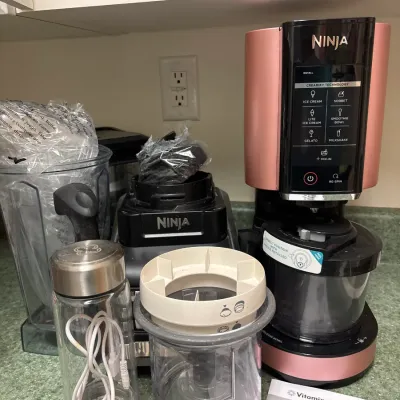 Ninja Creami ice cream maker in rose gold, along with a Ninja blender base, additional blender attachments, a small portable blender, and...