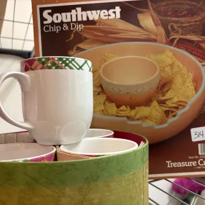 Set of ceramic mugs with colorful plaid trim in a round hat-style box, displayed in front of a vintage Treasure Craft Southwest Chip...