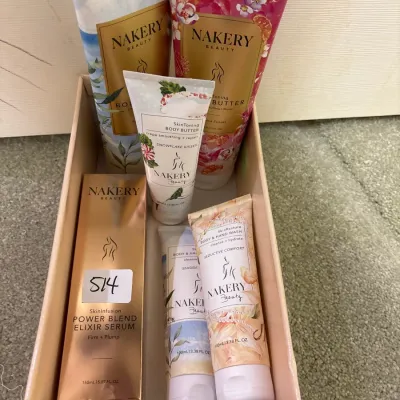 Collection of Nakery Beauty skincare products, including body butter, wash, and Power Blend Elixir Serum arranged in a tray.