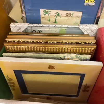 Assortment of framed art and picture frames, including a Beatrix Potter-themed frame, ornate gilded wood frames, and a framed tropical...