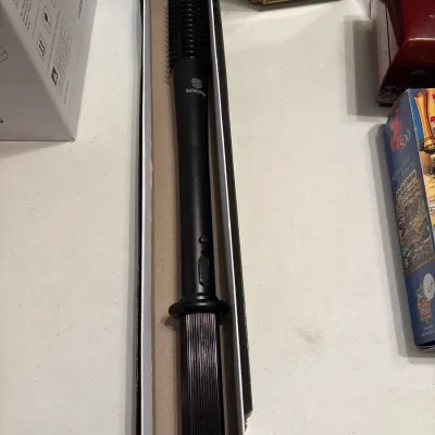 SafetyVital black extendable self-defense baton with spiked head, shown in its original long cardboard box.