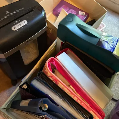 Ativa 10-sheet paper shredder alongside various office supplies, binders, spiral notebooks, and fabric storage bins.