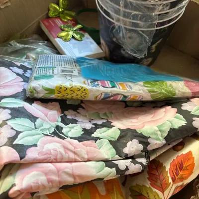 Box lot of seasonal decorations and textiles, including St. Patrick's Day shamrock accents, Halloween buckets, and printed tablecloths.