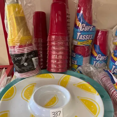 Melamine chip and dip server with a lemon print motif, lot 337, displayed alongside unopened packs of disposable plastic party cups.